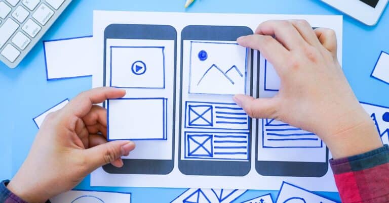 Hands moving around pieces of a website design