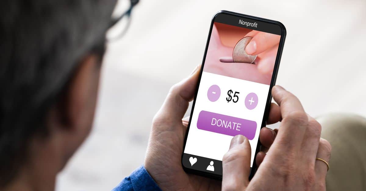 Man holding phone about to make a donation to a nonprofit Man holding phone about to make a donation to a nonprofit