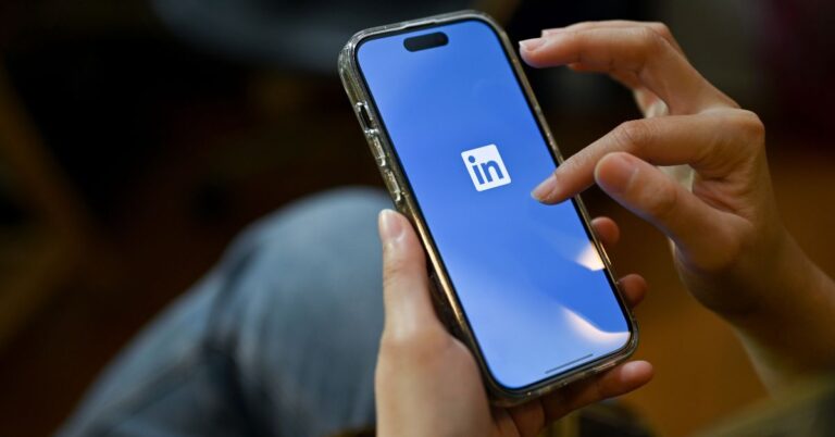 Person holding phone with LinkedIn app logo