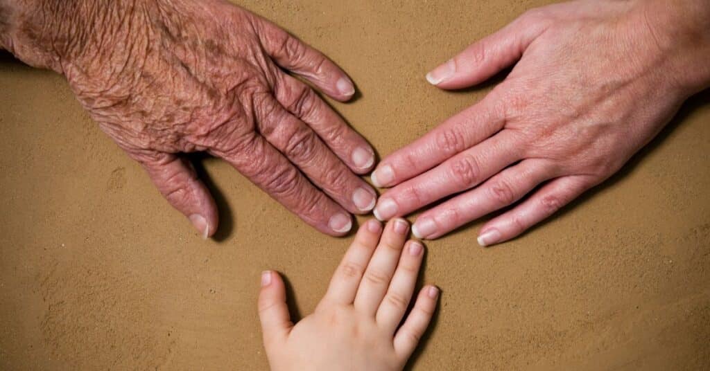 Different generation hands touching in middle