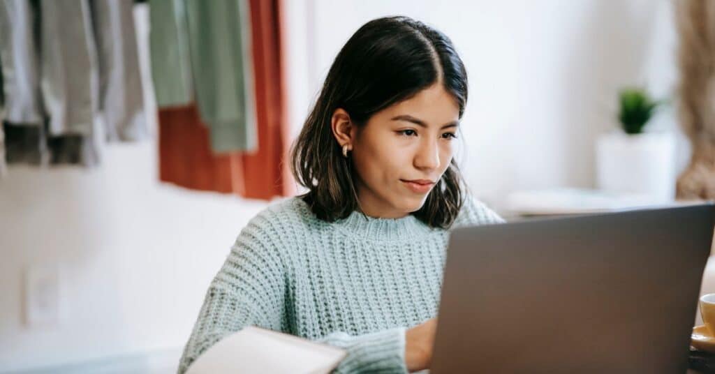 Woman sitting in front of a latpop